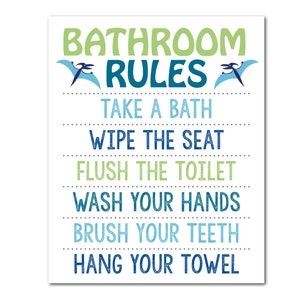 May include: A rectangular sign with the words "BATHROOM RULES" in green and blue, with dinosaur illustrations. The sign lists bathroom rules: Take a bath, wipe the seat, flush the toilet, wash your hands, brush your teeth, and hang your towel.