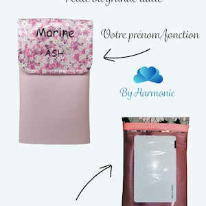 Puede incluir: Una funda magn&eacute;tica rosa con una solapa estampada con flores. La solapa est&aacute; impresa con el nombre "Marine" y "ASH". La funda tiene un bolsillo exterior y est&aacute; dise&ntilde;ada para guardar tarjetas.