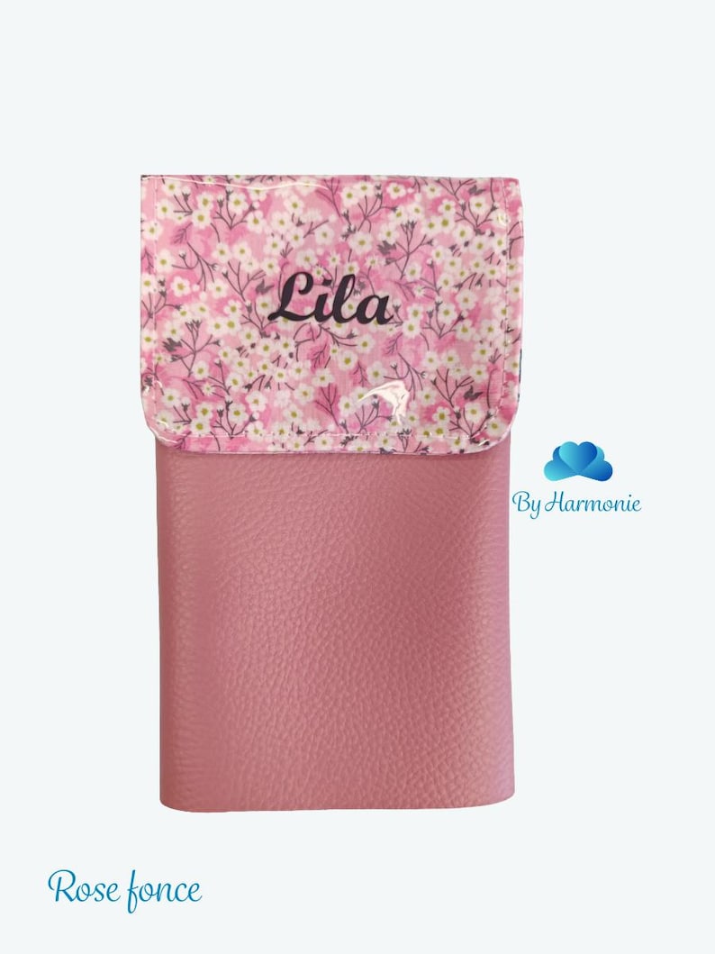 Puede incluir: Un estuche rosa con una solapa estampada con flores. La solapa presenta un dise&ntilde;o floral blanco y rosa con el nombre "Lila" en escritura negra. El cuerpo principal del estuche es rosa liso y texturizado.