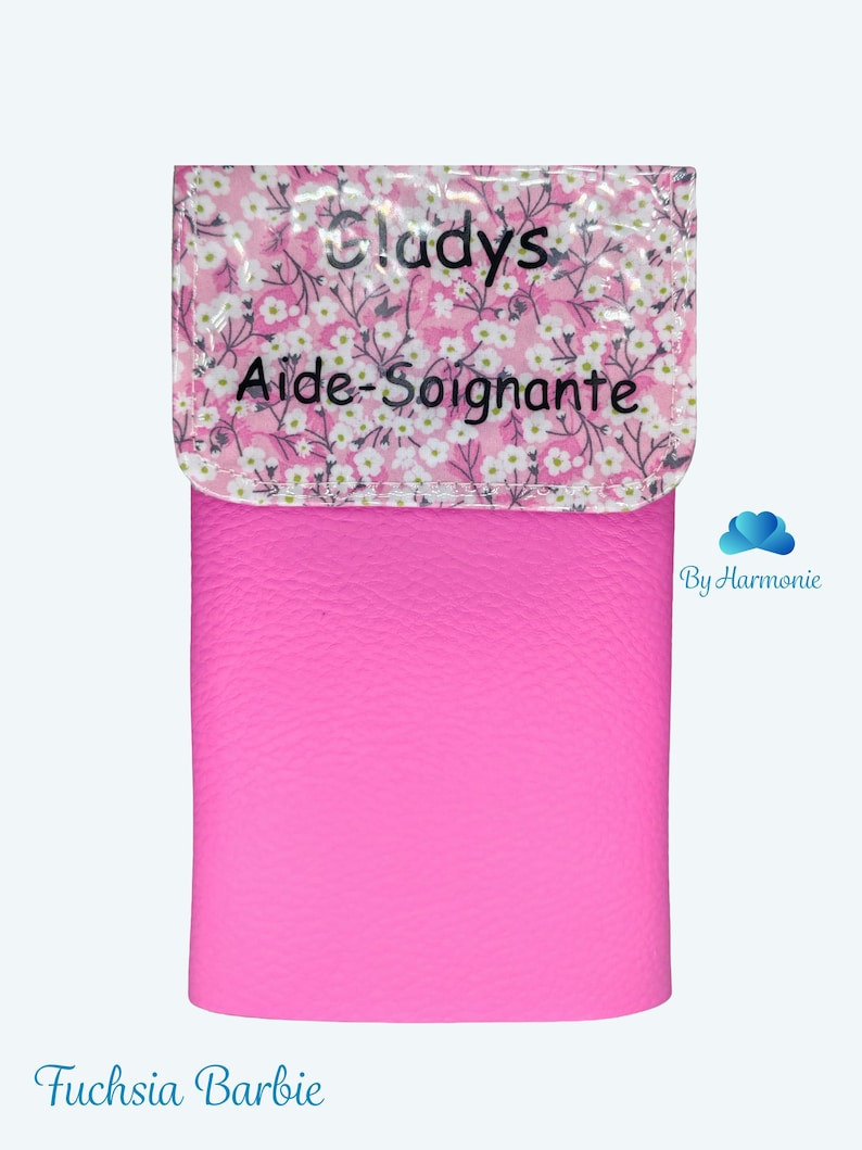 Puede incluir: Un estuche rosa fucsia con una solapa estampada con flores. La solapa tiene el nombre "Gladys" y las palabras "Aide-Soignante" impresas. La parte inferior del estuche tiene las palabras "Fuchsia Barbie" impresas.