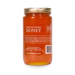 Puede incluir: Un tarro de vidrio de miel pura del sur con una tapa dorada. La etiqueta dice "Pure Southern Honey" y "Georgia Grown". El tarro est&aacute; sobre un fondo blanco. Los datos nutricionales y los ingredientes est&aacute;n listados en la etiqueta. El tarro es producido y envasado por Deep South Honey, LLC.