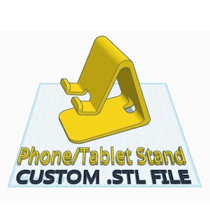 Pode incluir: Um suporte para telefone ou tablet impresso em 3D de cor amarela. O suporte é projetado para segurar um dispositivo na posição vertical. A imagem inclui o texto "Phone/Tablet Stand CUSTOM .STL FILE".
