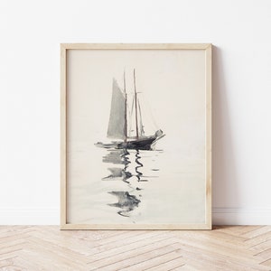 May include: A framed watercolor painting of a sailboat with white sails on a calm body of water. The sailboat is in the center of the image and is facing the viewer. The water is a light blue color and there are ripples on the surface. The sky is a light gray color.