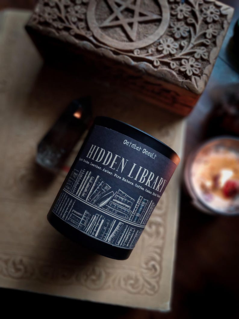 May include: A white ceramic mug with a black handle and the text "But First, Coffee" in a black, handwritten-style font. The mug is on a white surface.