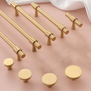 Puede incluir: Un juego de herrajes para armarios de color dorado, que incluye tiradores y pomos. Los tiradores están disponibles en varias longitudes, y los pomos son redondos.