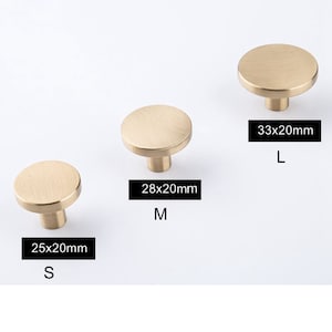 May include: Three brass cabinet knobs in different sizes. The smallest knob is 2.5 inches by 2 inches, the middle knob is 2.8 inches by 2 inches, and the largest knob is 3.3 inches by 2 inches. The knobs are all round and have a smooth, brushed finish.