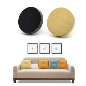 May include: Two round cabinet knobs, one black and one gold. The knobs are shown against a white background.