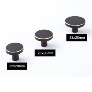 May include: Three black cabinet knobs with a gold trim. The knobs are 25x20mm, 28x20mm, and 33x20mm.