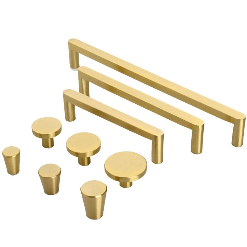 May include: A set of gold cabinet hardware, including three different sizes of bar pulls and four different sizes of round knobs.