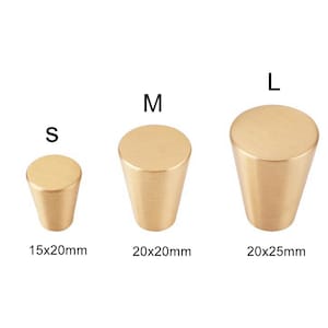 May include: Three gold-toned metal cabinet knobs in different sizes: small, medium, and large. The knobs are cone-shaped with a rounded top. The sizes are labeled S, M, and L, with measurements in millimeters: 15x20mm, 20x20mm, and 20x25mm.
