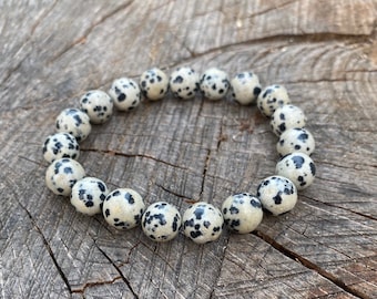 May include: A bracelet made of round, white and black speckled beads.