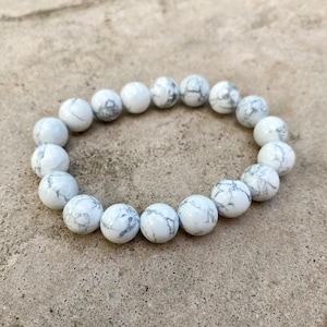 Op de afbeelding: Witte howliet kralen armband met ronde kralen. De kralen hebben een marmerpatroon.