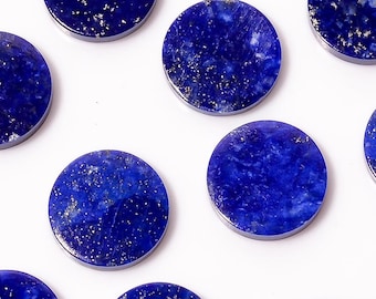 May include: Twelve circular lapis lazuli stones, each a deep blue with gold flecks, are displayed on a white background. These polished stones are suitable for jewellery making or craft projects. The stones are approximately 2.5 cm in diameter.