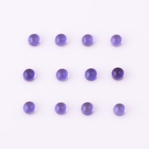 May include: Twelve round, purple gemstones arranged in three rows of four on a white background.