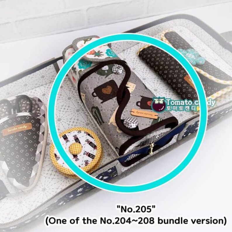 May include: A close-up of a gray and white fabric pouch with a zipper closure. The pouch is decorated with a pattern of teacups and hearts. The pouch is labeled "No. 205" and is part of a bundle of similar pouches.