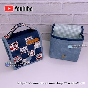 Puede incluir: Dos bolsas de tela azul con un patrón a cuadros en el interior. Una bolsa tiene un asa y está hecha de tela de patchwork con diseños florales rojos y blancos. Ambas bolsas tienen un pequeño cierre de botón y una etiqueta que dice "Tomato candy".
