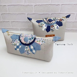 May include: Two light grey quilted pouches with gold-tone zips. Each features a decorative fan-shaped appliqué made of blue, white, and floral fabric patches with a central button. The text TomatoQuilt and TomatoCandy is visible on the items.