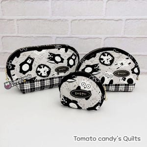 Pode incluir: Três bolsas de tecido acolchoadas em preto e branco com uma estampa de animais caprichosa. As bolsas são de tamanhos diferentes e têm uma borda xadrez preto e branco. A bolsa maior tem o texto "Tomato candy".