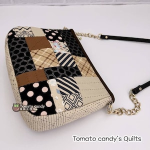 May include: A patchwork fabric handbag with a gold chain strap and a black leather strap. The bag is made of various fabrics in black, brown, beige, and white with geometric and floral patterns. The bag has a quilted design and the text "Tomato candy's Quilts" is visible below the bag.