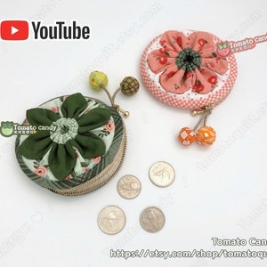K&ouml;nnte beinhalten: Zwei runde M&uuml;nzbeutel mit floralen Stoffdesigns. Eine B&ouml;rse ist gr&uuml;n mit einem wei&szlig;en Blumenmuster und die andere ist rosa mit einem wei&szlig;en und roten Kirschmuster. Beide Beutel haben einen Rei&szlig;verschluss und einen kleinen Quasten.