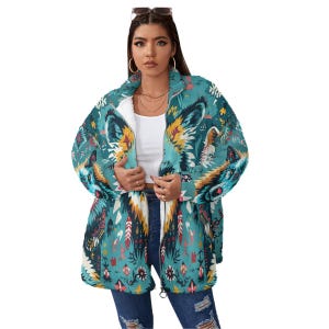 Könnte beinhalten: Türkisfarbene Kapuzenjacke mit farbenfrohem Wolfsdesign. Die Jacke hat ein weißes Innenfutter und einen durchgehenden Reißverschluss. Das Design umfasst Federn, Blumenmuster und geometrische Formen in Gelb, Rot und Weiß.