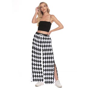 Puede incluir: Top corto negro y pantalones de pernera ancha con un estampado de rombos en blanco y negro. Los pantalones tienen cintura con cordón y aberturas laterales. El conjunto se lleva con zapatillas blancas.