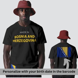 Peut inclure: T-shirt noir avec l'inscription jaune "MADE IN BOSNIA AND HERZEGOVINA". Le dos du t-shirt présente un motif de code-barres intégrant le drapeau bosnien. Un chapeau de pêcheur rouge est porté. Le texte "Personnalisez avec votre date de naissance dans le code-barres" est en bas.