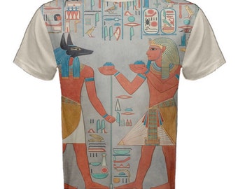 May include: A beige t-shirt with a colorful print of an ancient Egyptian scene. The print features two figures, one with a jackal head and the other with a human head, both holding objects in their hands. The background is filled with hieroglyphs.