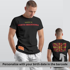 Peut inclure: T-shirt noir avec l'inscription "MADE IN NORTH MACEDONIA" en jaune et rouge. Comporte un petit drapeau et un motif de code-barres au dos avec le texte "1993 0407".