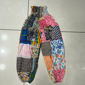 Op de afbeelding: Patchwork broek met een kleurrijk bloemen- en geometrisch patroon. De broek heeft een elastische tailleband en een losse pasvorm.