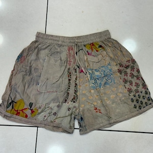 Op de afbeelding: Beige patchwork shorts met een bloemenprint en een trekkoord.