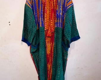 May include: A long-sleeved kimono-style robe featuring a vibrant tie-dye pattern in shades of red, orange, blue, and green. The garment has a central vertical panel with a red and orange tie-dye design, flanked by green side panels with dark accents.
