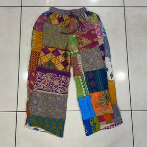 May include: Patchwork pants with a variety of colors and patterns, including purple, blue, green, yellow, and red. The pants have a drawstring waist and a wide leg.