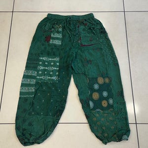 May include: Green patchwork trousers with a drawstring waist and a variety of floral and geometric patterns.