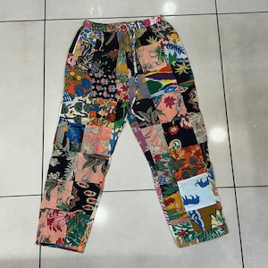 May include: Patchwork trousers with a colourful floral and geometric pattern. The trousers have a drawstring waist and a relaxed fit.