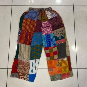 May include: Patchwork pants with a variety of colors and patterns, including blue, green, red, orange, and brown. The pants have a drawstring waist and a relaxed fit.