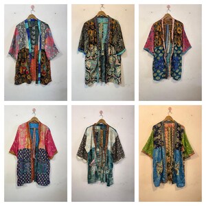 Può includere: Una collezione di sei kimono patchwork colorati appesi a grucce di legno. Le giacche presentano una varietà di motivi e colori, tra cui floreali, paisley e geometrici. Ogni giacca ha maniche corte e un davanti aperto, lungo circa 75 cm.