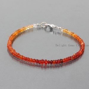 Può includere: Un braccialetto delicato realizzato con piccole perle rotonde di opale arancio e giallo. Il braccialetto ha una chiusura argentata.
