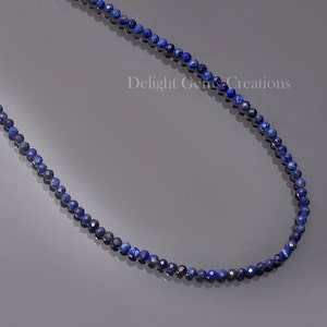 May include: A necklace made of small, round, dark blue lapis lazuli beads. The necklace is approximately 18 inches long.