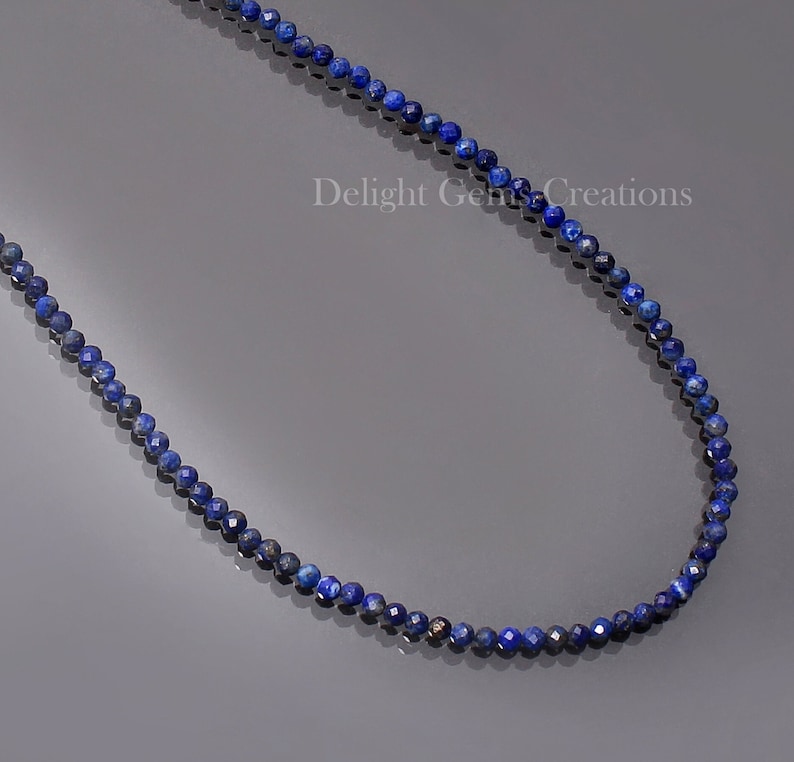 May include: A necklace made of small, round, dark blue lapis lazuli beads. The necklace is approximately 18 inches long.