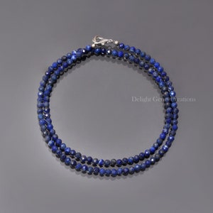 May include: A double strand necklace made with dark blue faceted lapis lazuli beads. The necklace has a silver clasp.