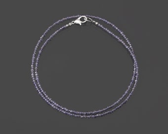 May include: A silver necklace with a double strand of small, light purple beads.