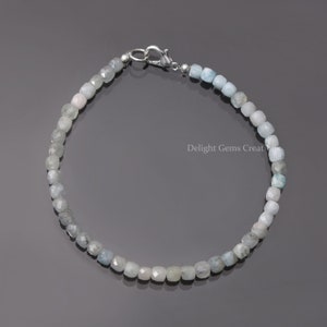 Puede incluir: Un delicado brazalete de piedras preciosas de aguamarina con cierre de plata. Las cuentas son facetadas y tienen un degradado de color de azul claro a blanco.