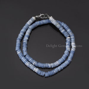 May include: A light blue opal bead necklace with a silver clasp. The necklace is made of many small, round beads that are strung together.