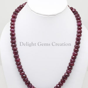 Puede incluir: Un collar hecho de cuentas de rubí rojo oscuro. Las cuentas son facetadas y tienen un acabado pulido. El collar mide aproximadamente 45 cm de largo.