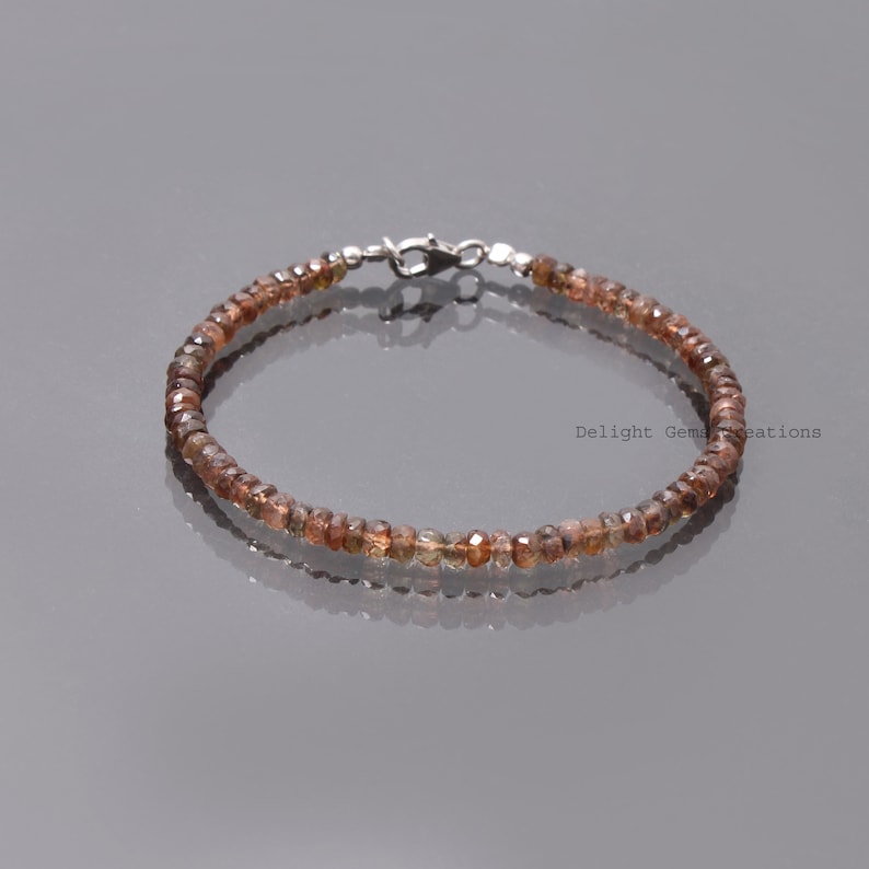 May include: A delicate brown gemstone bracelet with a silver clasp. The bracelet is made of small, faceted gemstones and is approximately 7 inches in length.
