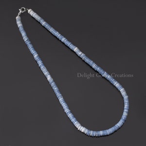 May include: A light blue opal beaded necklace with a silver clasp. The necklace is made of small, round beads that are strung together to create a long, flowing strand.