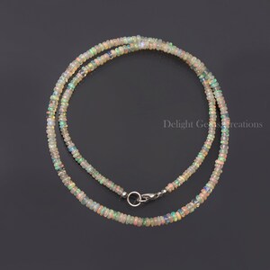 Puede incluir: Un collar delicado hecho con peque&ntilde;as cuentas de &oacute;palo iridiscente. El collar es de color plateado y tiene un cierre de mosquet&oacute;n.