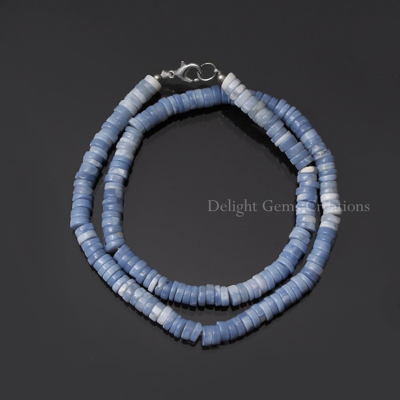 May include: A light blue opal bead necklace with a silver clasp. The necklace is made of many small, round beads that are strung together.