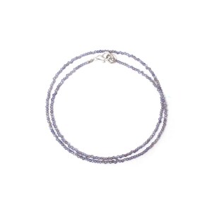 May include: A delicate silver chain necklace with small, light purple beads. The necklace is layered and has a silver clasp.